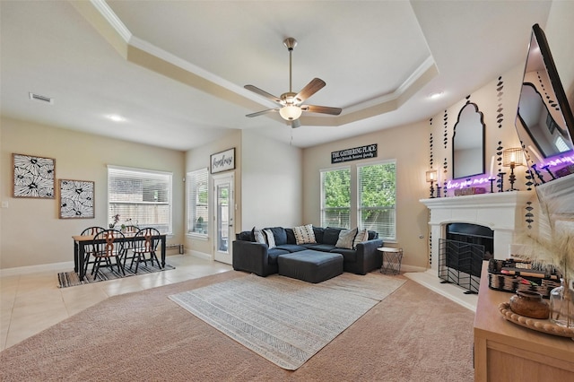 528 England St, Fate, TX 75189 - living room featuring a raised ceiling, ornamental molding, baseboards, ceiling fan, and a fireplace with raised hearth