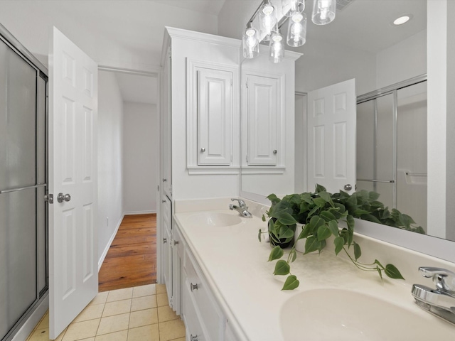 14130 Red Wood Cir S, Frisco, TX 75071 - full bath with double vanity, tile patterned floors, and an enclosed shower