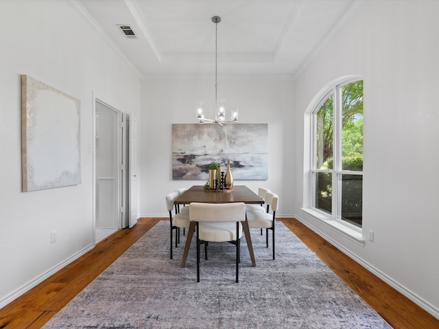 14130 Red Wood Cir S, Frisco, TX 75071 - dining area with wood finished floors, a chandelier, ornamental molding, a raised ceiling, and baseboards