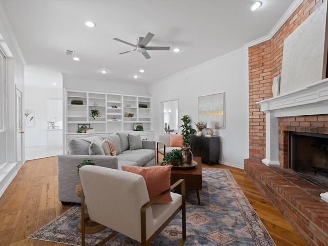 14130 Red Wood Cir S, Frisco, TX 75071 - living area with a ceiling fan, wood finished floors, a brick fireplace, ornamental molding, and recessed lighting