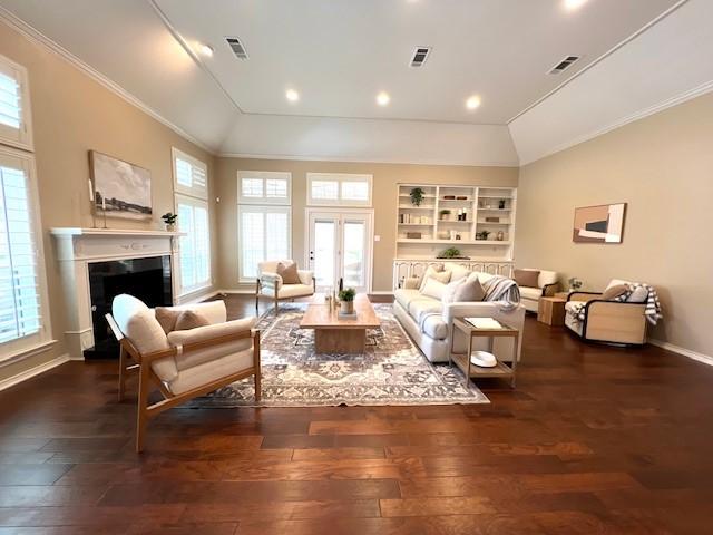7009 Chevy Chase Ave, Dallas, TX 75225 - living room with vaulted ceiling, hardwood / wood-style flooring, baseboards, ornamental molding, and a fireplace with raised hearth