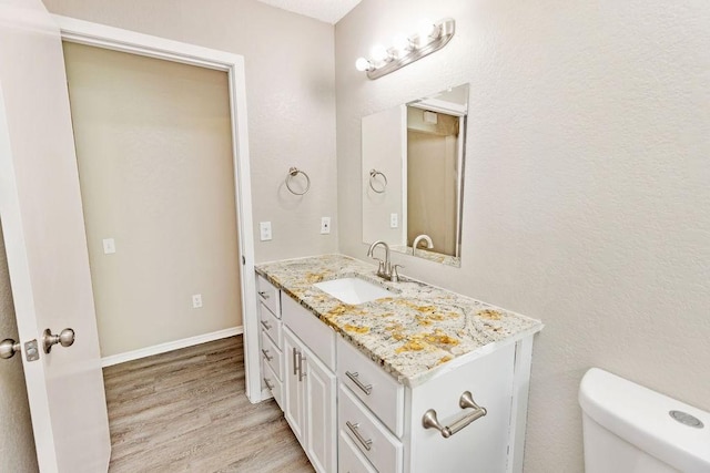 114 Juniper Dr, Arlington, TX 76018 - half bathroom featuring vanity, wood finished floors, toilet, and baseboards
