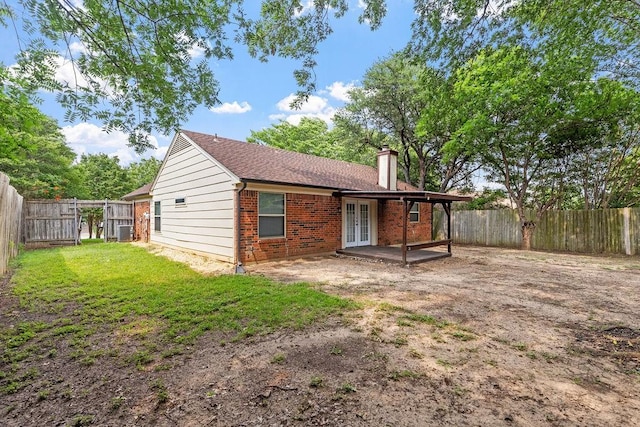 114 Juniper Dr, Arlington, TX 76018 - back of property with french doors, brick siding, cooling unit, a chimney, and a patio area