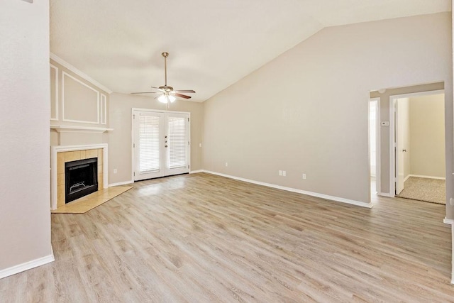 114 Juniper Dr, Arlington, TX 76018 - unfurnished living room with a ceiling fan, wood finished floors, a tiled fireplace, vaulted ceiling, and baseboards