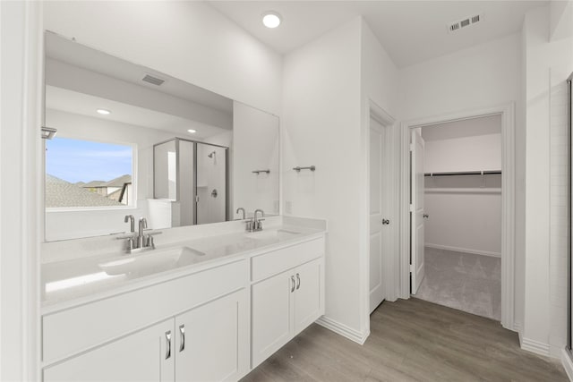 713 Roanoke, Princeton, TX 75407 - full bathroom featuring a stall shower, a walk in closet, double vanity, wood finished floors, and recessed lighting