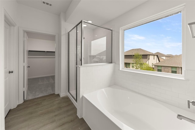 713 Roanoke, Princeton, TX 75407 - full bath with a spacious closet, a stall shower, a garden tub, and wood finished floors