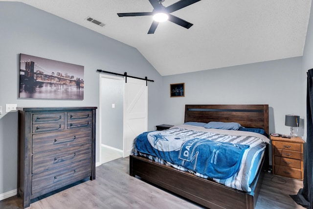 1623 Bertram Dr, Mansfield, TX 76063 - bedroom featuring a barn door, wood finished floors, vaulted ceiling, baseboards, and ceiling fan