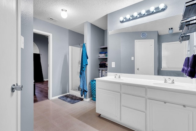 1623 Bertram Dr, Mansfield, TX 76063 - full bath with a stall shower, double vanity, a textured ceiling, and baseboards