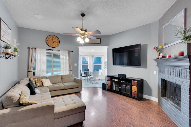 1623 Bertram Dr, Mansfield, TX 76063 - living room with a ceiling fan, a textured ceiling, wood finished floors, and a fireplace