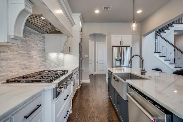 15186 Crape Myrtle Rd, Frisco, TX 75035 - kitchen with appliances with stainless steel finishes, a sink, custom range hood, light stone counters, and white cabinetry