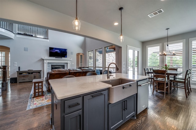 15186 Crape Myrtle Rd, Frisco, TX 75035 - kitchen featuring a sink, dark wood-type flooring, a fireplace, arched walkways, and recessed lighting
