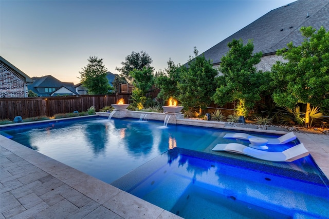 15186 Crape Myrtle Rd, Frisco, TX 75035 - pool at dusk featuring a fenced backyard and a pool with connected hot tub