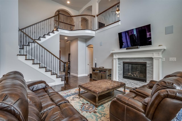 15186 Crape Myrtle Rd, Frisco, TX 75035 - living room featuring wood finished floors, stairway, a high ceiling, a fireplace, and baseboards