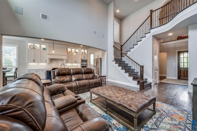 15186 Crape Myrtle Rd, Frisco, TX 75035 - living area with a towering ceiling, stairway, dark wood-type flooring, baseboards, and recessed lighting