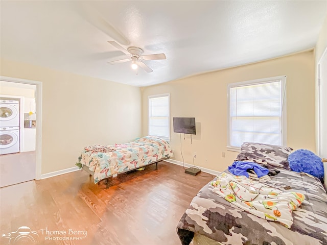 3816 State St, Abilene, TX 79603 - bedroom featuring stacked washer / dryer, wood finished floors, baseboards, and a ceiling fan