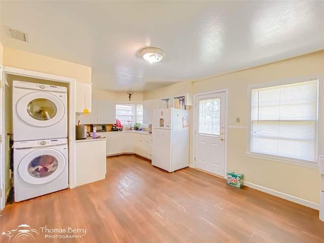 3816 State St, Abilene, TX 79603 - laundry room with stacked washer and clothes dryer, light wood finished floors, and plenty of natural light