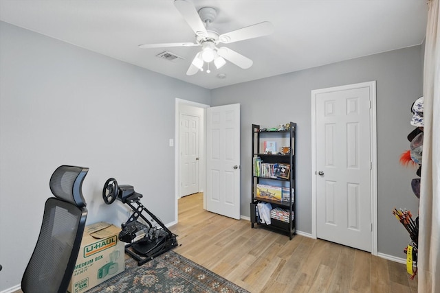 216 Hilltop Dr, Justin, TX 76247 - workout room with light wood-style flooring, ceiling fan, and baseboards