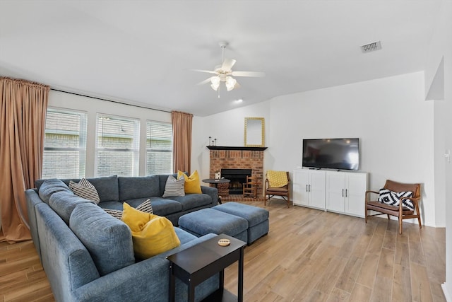 216 Hilltop Dr, Justin, TX 76247 - living room featuring ceiling fan, light wood-style flooring, vaulted ceiling, and a brick fireplace