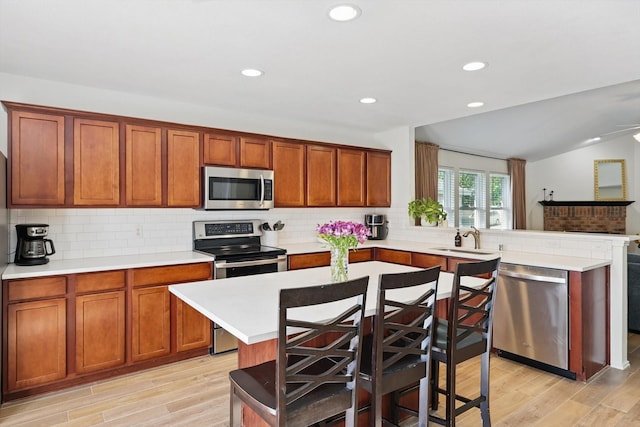 216 Hilltop Dr, Justin, TX 76247 - kitchen with appliances with stainless steel finishes, a sink, light countertops, a peninsula, and decorative backsplash