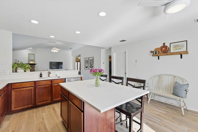 216 Hilltop Dr, Justin, TX 76247 - kitchen with ceiling fan, a sink, light wood-type flooring, a kitchen bar, and recessed lighting
