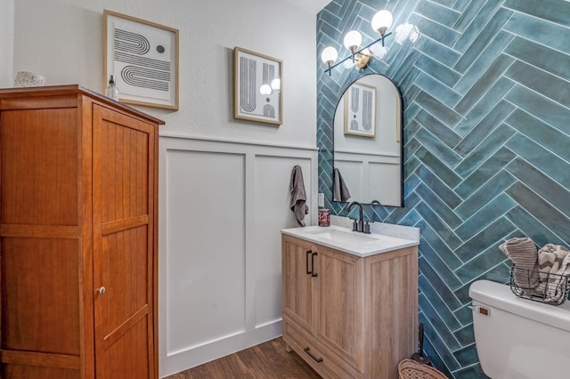 8320 Monica Cir, Plano, TX 75025 - half bath with vanity, a chandelier, toilet, a wainscoted wall, and a decorative wall