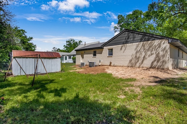 1538 N Hill Ave, Tyler, TX 75702 - rear view of property with cooling unit, a lawn, and brick siding