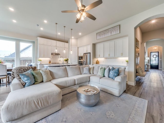 2724 Eccleston St, Celina, TX 75009 - living area featuring arched walkways, ceiling fan, light wood finished floors, and recessed lighting