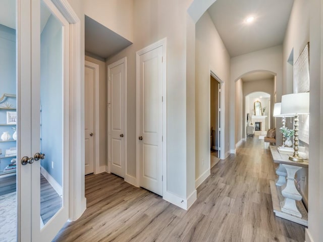 2724 Eccleston St, Celina, TX 75009 - hallway with arched walkways, light wood-style floors, and baseboards