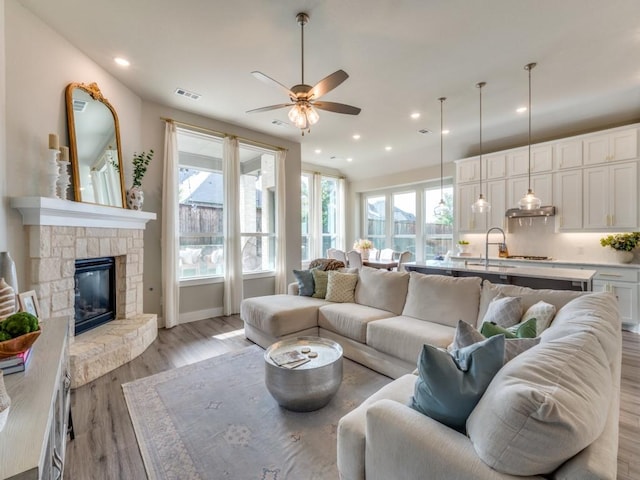 2724 Eccleston St, Celina, TX 75009 - living area featuring a ceiling fan, plenty of natural light, light wood-style flooring, recessed lighting, and a stone fireplace