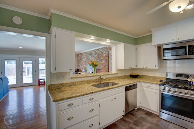 444 Albert Ave, Shreveport, LA 71105 - kitchen featuring stainless steel appliances, a sink, ornamental molding, tasteful backsplash, and white cabinets