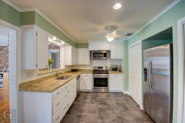 444 Albert Ave, Shreveport, LA 71105 - kitchen featuring appliances with stainless steel finishes, a sink, light stone countertops, white cabinetry, and crown molding