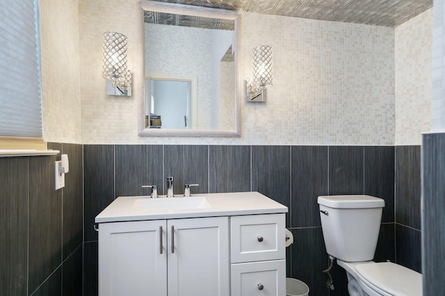 6853 Anglebluff Cir, Dallas, TX 75248 - bathroom with toilet, vanity, and tile walls