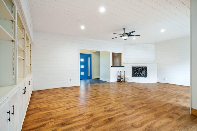 6853 Anglebluff Cir, Dallas, TX 75248 - unfurnished living room featuring ceiling fan, wood finished floors, recessed lighting, a fireplace, and wood walls