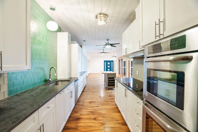 6853 Anglebluff Cir, Dallas, TX 75248 - kitchen with a sink, stainless steel appliances, light wood-style floors, white cabinets, and tasteful backsplash