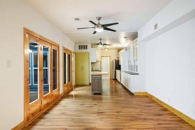 6853 Anglebluff Cir, Dallas, TX 75248 - kitchen with freestanding refrigerator, ceiling fan, light wood finished floors, white cabinetry, and baseboards