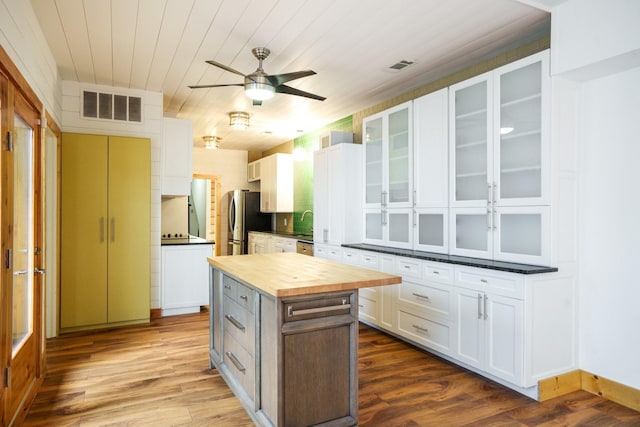6853 Anglebluff Cir, Dallas, TX 75248 - kitchen with butcher block countertops, freestanding refrigerator, white cabinetry, ceiling fan, and dark wood-style floors