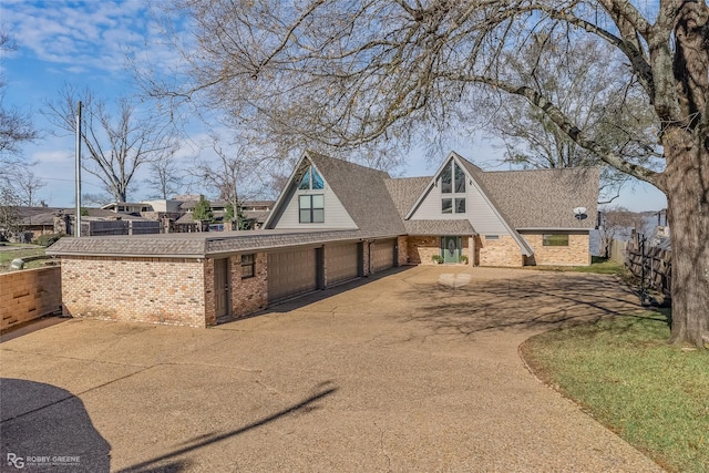 5607 S Lakeshore Dr, Shreveport, LA 71119 - a-frame home with brick siding, asphalt driveway, roof with shingles, and a garage