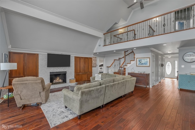 5607 S Lakeshore Dr, Shreveport, LA 71119 - living area with a ceiling fan, dark wood-style flooring, high vaulted ceiling, stairway, and a fireplace