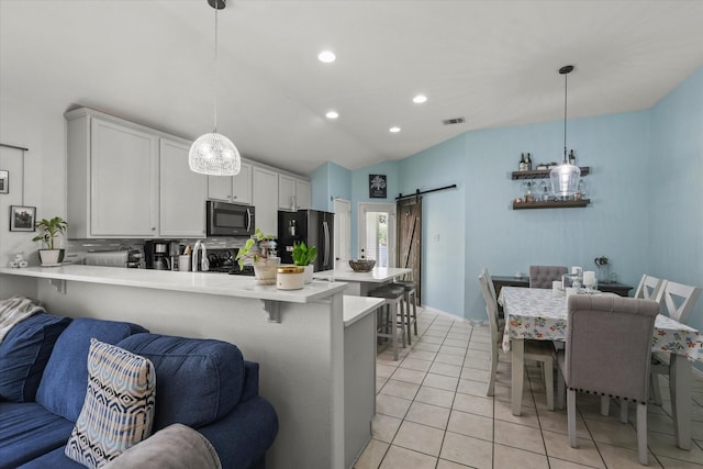 1521 Cherokee Rose Trl, Savannah, TX 76227 - kitchen with freestanding refrigerator, light countertops, a barn door, a peninsula, and open floor plan