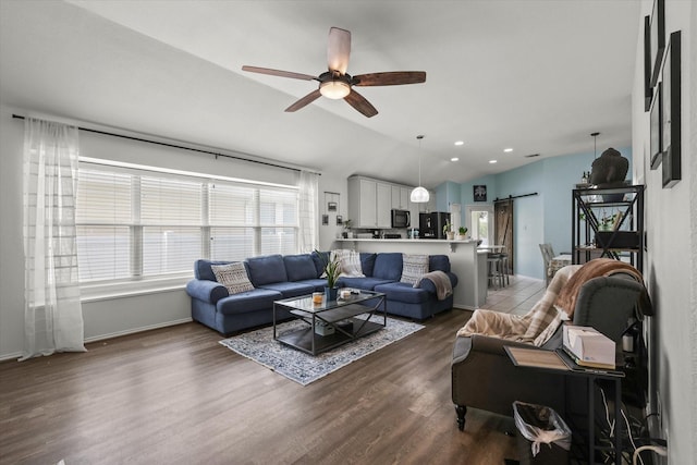 1521 Cherokee Rose Trl, Savannah, TX 76227 - living room with a barn door, ceiling fan, dark wood-style flooring, lofted ceiling, and baseboards