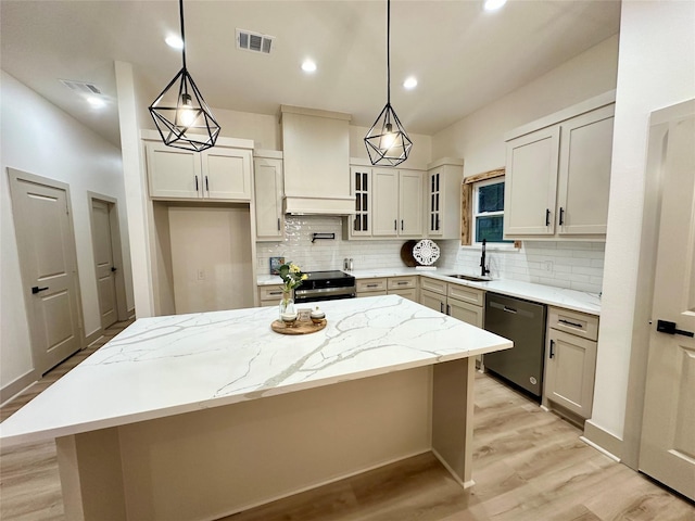 400 N Kenny Dr, West Tawakoni, TX 75474 - kitchen featuring appliances with stainless steel finishes, light wood-style flooring, tasteful backsplash, a sink, and a center island
