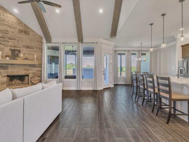 3025 Infinity Dr, Weatherford, TX 76087 - living room featuring ceiling fan, dark wood-style floors, a stone fireplace, baseboards, and crown molding