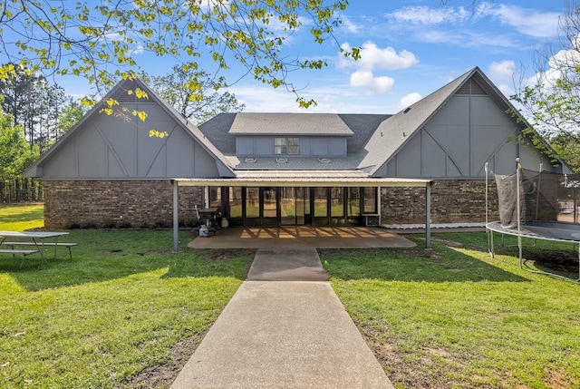 213 County Road 1407, Jacksonville, TX 75766 - rear view of house with a trampoline, brick siding, a lawn, and a shingled roof