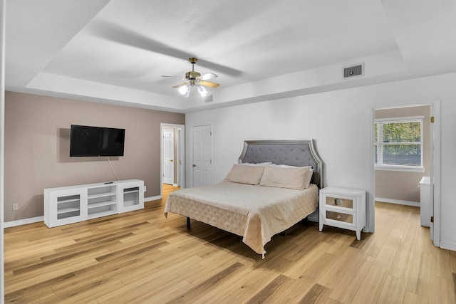 213 County Road 1407, Jacksonville, TX 75766 - bedroom with a raised ceiling, baseboards, light wood-style floors, and a ceiling fan