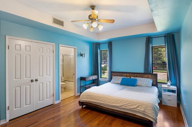 213 County Road 1407, Jacksonville, TX 75766 - bedroom featuring wood finished floors, baseboards, ensuite bathroom, ceiling fan, and a closet