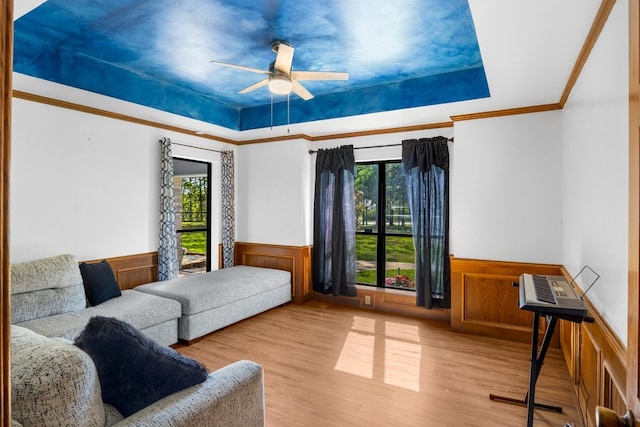 213 County Road 1407, Jacksonville, TX 75766 - bedroom with wainscoting, multiple windows, a tray ceiling, wood finished floors, and crown molding