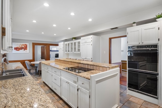 213 County Road 1407, Jacksonville, TX 75766 - kitchen featuring black appliances, a sink, white cabinetry, a center island, and light stone countertops