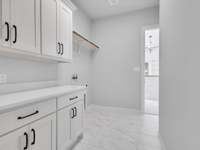 213 Martin Dr, Granbury, TX 76049 - laundry area featuring light marble finish flooring, cabinet space, washer hookup, and baseboards