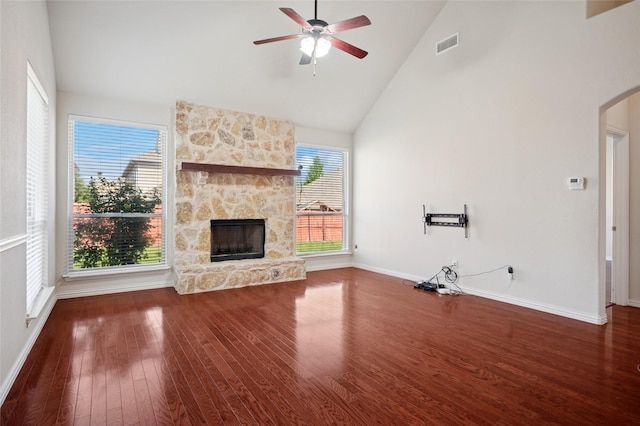 9004 Mcfarland Way, Fort Worth, TX 76244 - unfurnished living room with high vaulted ceiling, a stone fireplace, wood finished floors, arched walkways, and a ceiling fan
