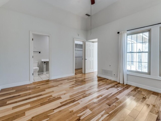 4713 N O Connor Ct, Irving, TX 75062 - unfurnished bedroom featuring light wood finished floors, baseboards, ensuite bathroom, a spacious closet, and ceiling fan